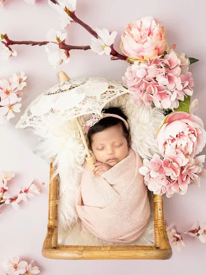 Another beautiful floral portrait. This newborn sleeps under a tiny lace umbrella, surrounded by pink peonies and cherry blossoms.