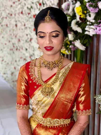 A classic South Indian bridal look is timeless. For Prakruthi's Muhurtham, we chose a bold red lip and shimmering gold eyeshadow to perfectly complement her traditional red and gold Kanjivaram saree and temple jewellery.