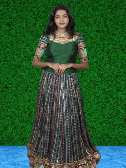 A gorgeous green blouse with embroidered sleeves paired with a multi-patterned striped lehenga skirt. This is a unique and artistic ethnic outfit for rent.