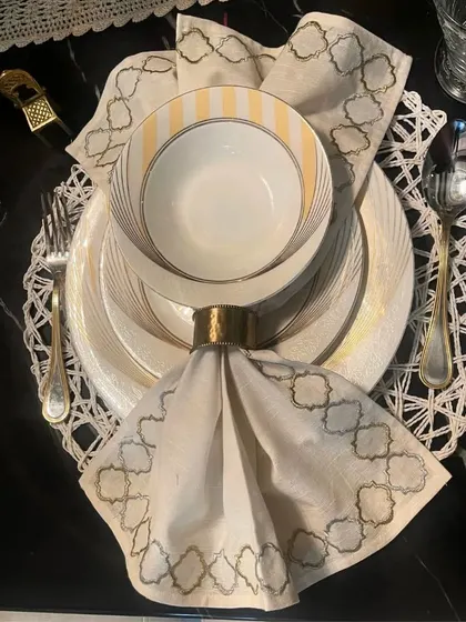 Elegantly arranged crockery atop a crisp, folded napkin creates a visually pleasing dining table. This place setting shows how attention to detail enhances the dining experience, combining functionality with aesthetics.