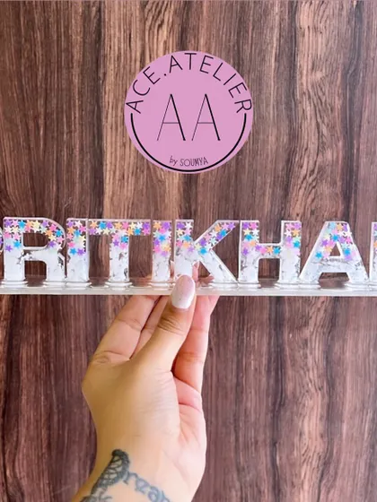 This 'Pritikhan' name stand features a mix of white and sparkling star glitter, giving it a magical and dreamy look. It's perfect for adding a touch of sparkle to any space.