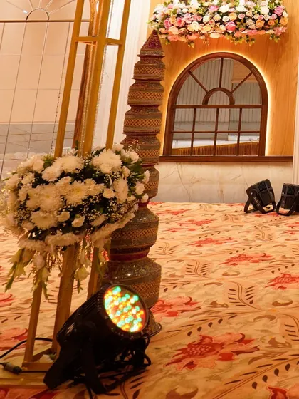 A detail shot of the wedding stage decor, showing the traditional pots and floral arrangements that add a cultural touch to the modern setup.