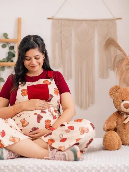 A sweet and serene moment with a teddy bear prop, perfect for a nursery-themed or casual maternity photo.
