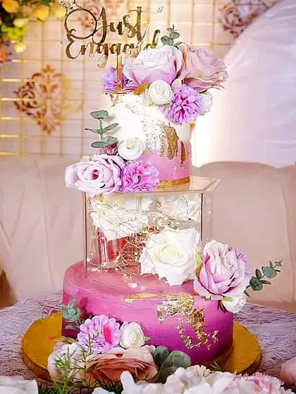 This three-tier "Just Engaged" cake in shades of pink and lavender features a spacer tier filled with white roses. It's a beautiful way to add a modern touch to a romantic theme.