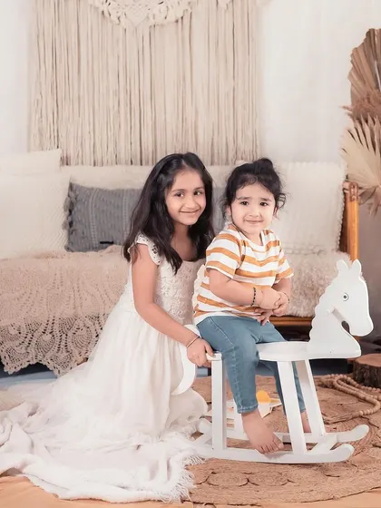 Two sisters playing in the studio. I love incorporating simple props like this rocking horse to bring out the children's playful side.