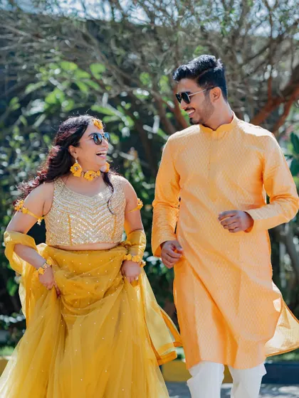 A happy couple, coordinated in shades of yellow, enjoying a sunny afternoon during their Haldi photoshoot. I help plan these moments to capture your love story perfectly.