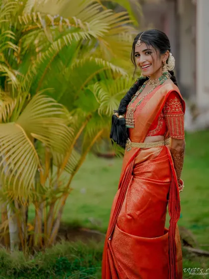 The bride's traditional braided hairstyle and elegant saree drape.