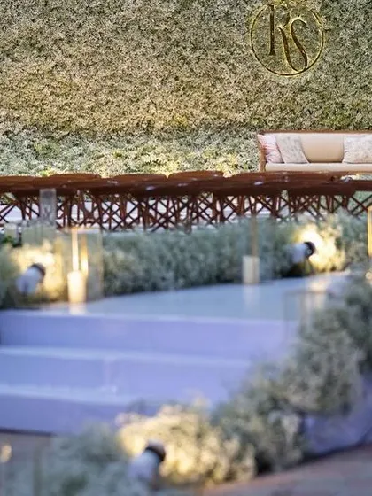 An ethereal all-white reception. The aisle and backdrop are adorned with clouds of baby's breath, while flickering candles cast a warm, romantic glow, creating a scene straight out of a fairy tale.