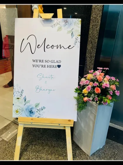 An elegant welcome sign for Shweta and Bhargav's event. The simple design with blue floral accents and a mix of script and serif fonts creates a classic and welcoming entrance.