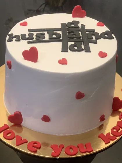 A special cake for a husband and dad. The clever design incorporates "Dad" and "Husband" into one, surrounded by little red hearts.