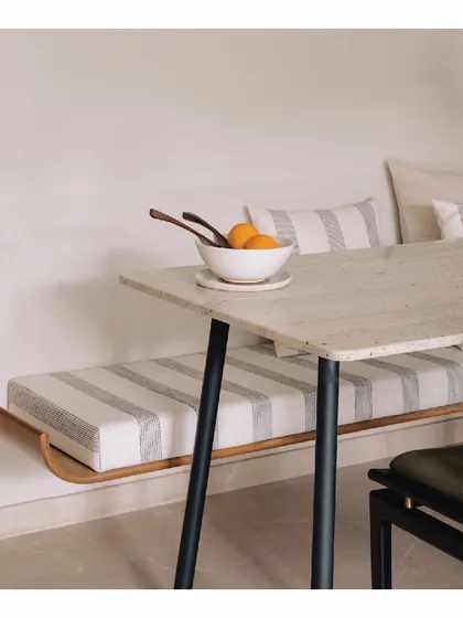 Inspired by the Wabi-Sabi aesthetic, this dining space features a sleek bench-style seating arrangement. The simple Indian marble top dining table and minimalist form create a clean, uncluttered look that is both functional and serene.