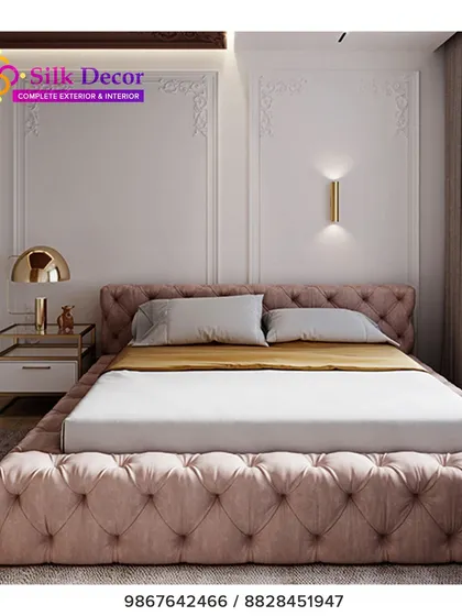 A closer look at one of our custom-built beds, designed to be a statement piece. The entire frame, from the headboard to the base, is fully upholstered in a dusty pink fabric with deep button tufting. This technique adds a layer of luxurious texture and visual interest to the bedroom.