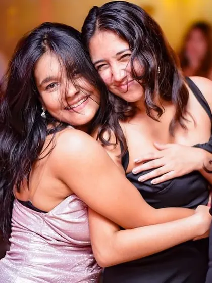 A warm hug between friends on the dance floor, making memories together.