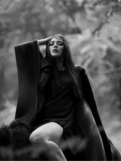 A powerful pose from the same black and white series, where the model's flowing robe and confident posture create a sense of drama.