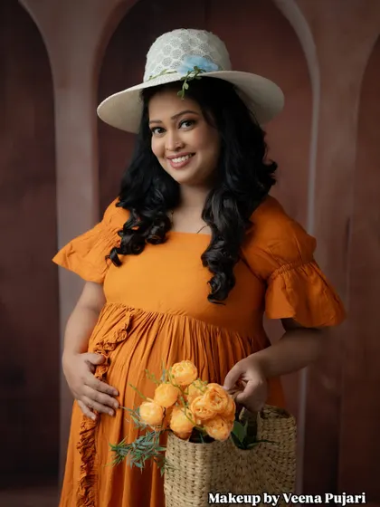 A cheerful and bright maternity photo. The hat and basket of flowers add a lovely, rustic charm to this modern maternity look.