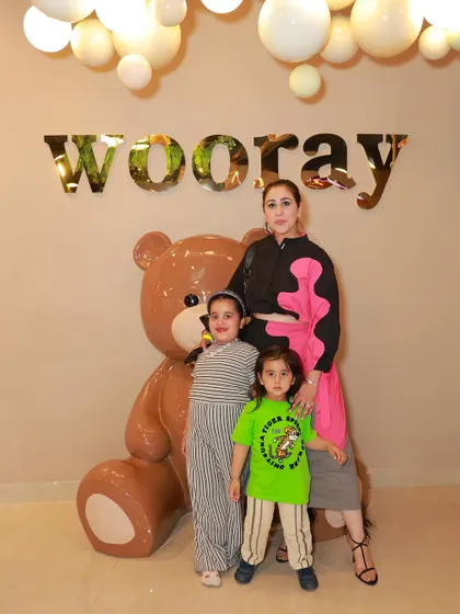 A mother and her children pose with our giant teddy bear mascot.