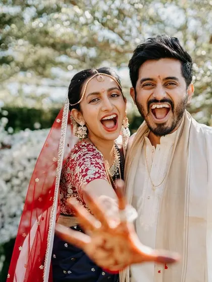 That "just married" energy! We love capturing the fun, spontaneous moments like this, with the couple showing off their henna-stained hands.
