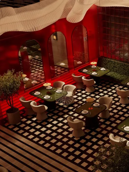 An overhead render view of a section of the restaurant, showing the checkered flooring, custom chairs, and the way the red walls create an immersive dining environment.