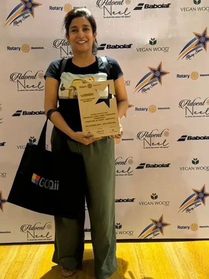Dr. Arlene Ghosh proudly holding the winner's plaque from the Rotary Club team championship.