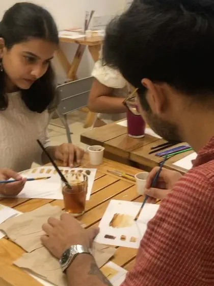 A participant and me during a coffee painting session. I love connecting with everyone and guiding them on their creative journey.