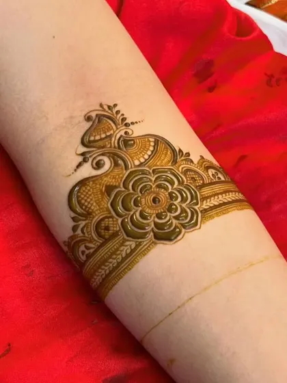 A stylish arm cuff design featuring a flower and peacock motif.