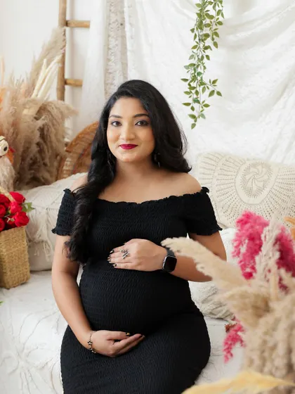 A beautiful close-up portrait in a cozy boho setting. The mom-to-be's gentle smile and the soft lighting create a warm and inviting atmosphere.