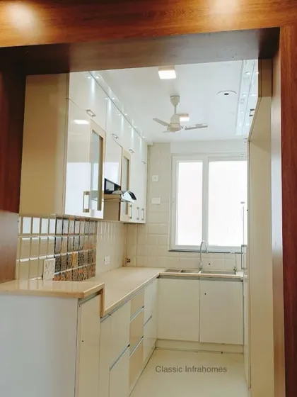 Another perspective of the Great Value Sarnam kitchen, showing the clean lines and open feel. The combination of open shelving, closed cabinets, and glass-front shutters provides a mix of storage and display options.