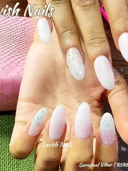A simple yet beautiful design with a milky white base and a light dusting of iridescent glitter on accent nails.
