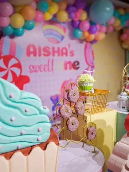 A detailed shot of the Candyland decor, with giant cupcake props and a donut display. The variety of shapes and colors makes the setup visually exciting.