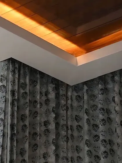 A corner detail showing automated cove lighting above curtains, demonstrating how lighting can enhance architectural features.