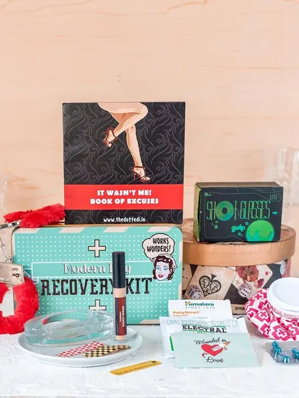 This is my "Modern Day Recovery Kit," a humorous gift for the morning after a big party. It includes fun items like a book of excuses, shot 'golgappas', and fuzzy handcuffs for a laugh.