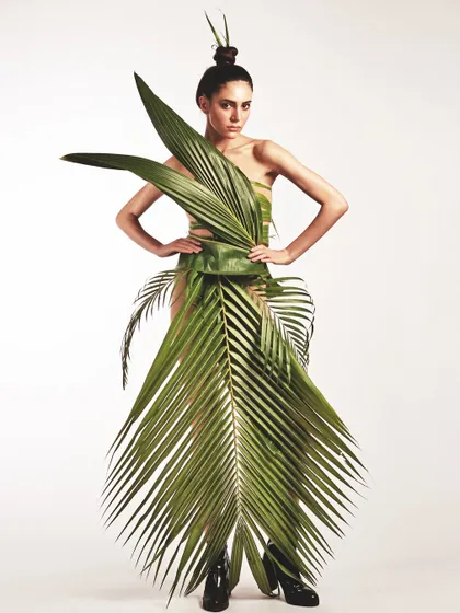 Creating a dress from nature itself. For this conceptual shoot, the makeup is kept clean and minimal to let the avant-garde leaf gown and the sculpted top-knot hairstyle take center stage.