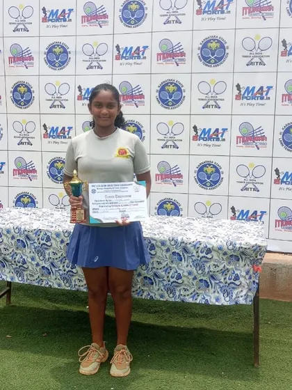 Eshita with her AITA SS U-14 Singles champion trophy. A solo shot celebrating a significant individual achievement.