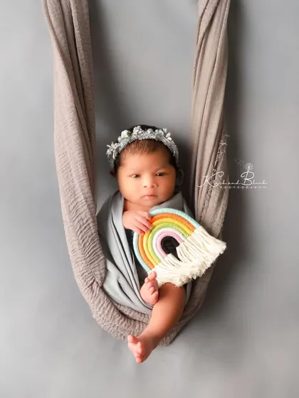 Just three days old and wide awake. This little one is looking right at my lens, holding a tiny rainbow, showing that beautiful newborn curiosity.