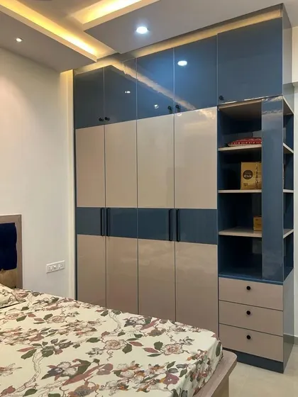 This wardrobe features a beautiful combination of oriental blue and mist grey laminates. The integrated open shelving provides a perfect spot for displaying decor or frequently used items.