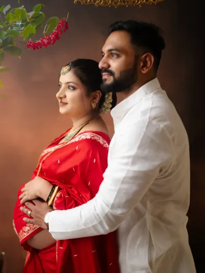 A tender moment between the expecting couple. His hand gently on her shoulder, they both look towards the future, creating a classic and heartfelt traditional portrait.
