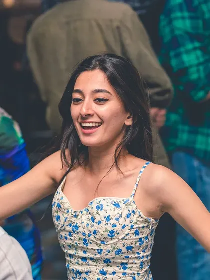 A woman with a beautiful, carefree smile, dancing without a worry. This is the vibe I work to create.