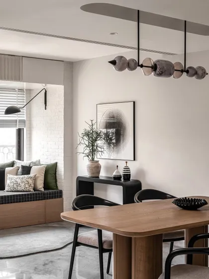 A sleek 6-seater oakwood table anchors this dining space, illuminated by a statement light fixture. To create separation from the guest room, I installed wooden and glass sliding doors with a pocket for seamless integration, ensuring both style and functionality.