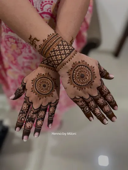 A classic design featuring a central mandala on the palm, surrounded by lotus patterns on the fingers. The wristband has a swastika for auspiciousness.