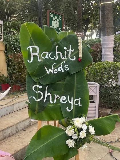 A personalized welcome sign written on banana leaves. This creative and eco-friendly detail is perfect for a South Indian or tropical-themed wedding, adding a unique and personal touch.