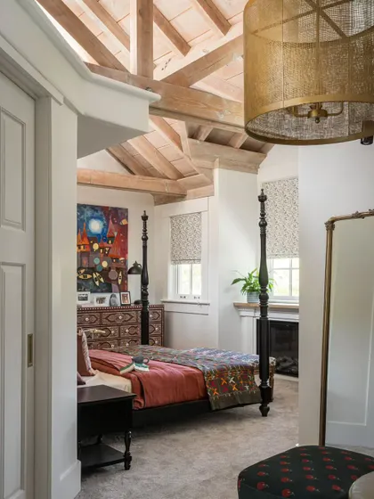 A view into the master bedroom of the Saratoga home, showcasing the four-poster bed and the high, beamed ceiling. The design feels both grand and intimate, a perfect retreat at the end of the day.