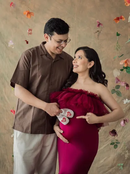 Pointing to the greatest adventure. This couple's portrait with tiny baby shoes is a sweet and simple way to announce their joy.