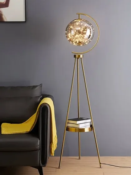 This tripod floor lamp is a perfect example of how we blend form and function. The antique brass finish, stable tripod base with a built-in shelf, and a glass globe filled with fairy lights make it a conversation starter that provides warm, ambient lighting.