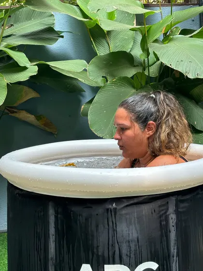 Finding focus in the cold. A member bravely embraces the invigorating challenge of a cold plunge, a key part of our recovery and wellness offerings.