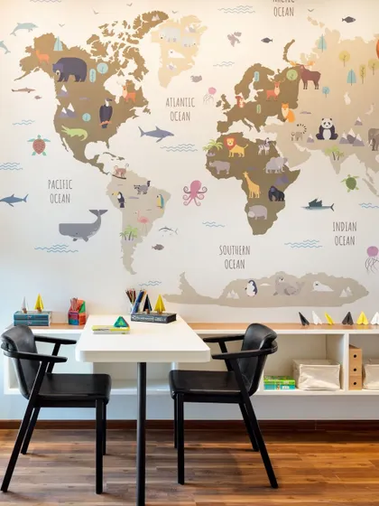A playful and educational workspace for children, featuring a world map mural and ample storage for creative supplies.