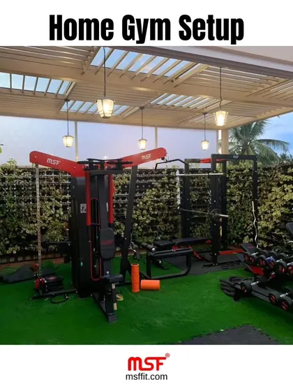 A beautiful home gym setup featuring our multi-functional trainer and dumbbell rack, set against a lush green wall.