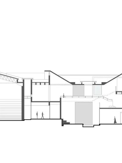 A detailed architectural section of a proposed institute in Goa. This drawing shows the complex relationship between different levels, including a sloped auditorium and various classroom spaces, all designed to integrate with the natural topography of the site.