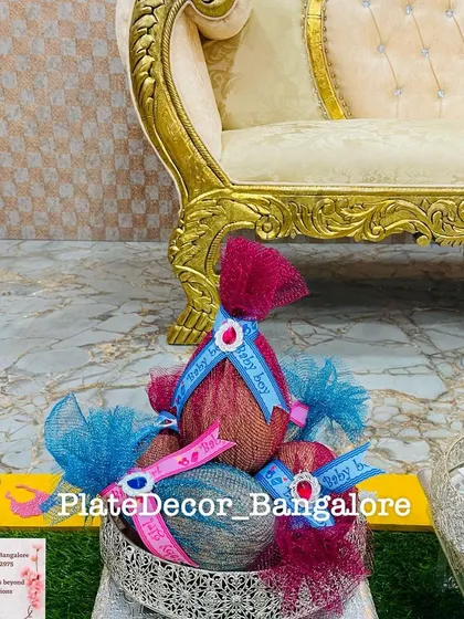 Coconuts decorated with blue net and 'Baby Boy' ribbons, presented in a silver basket. A simple and traditional gift for a seemantham.