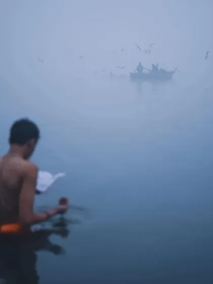 A devotee performs morning rituals in the foggy waters of the Ganga, with a boat faintly visible in the distance. This photo captures a moment of quiet solitude and faith.