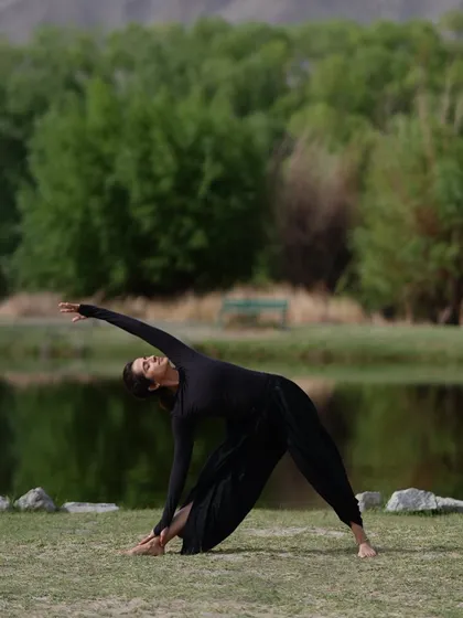 Practicing a variation of Trikonasana (Triangle Pose) in the crisp mountain air of Ladakh. The natural surroundings provide the perfect backdrop for a grounding and expansive yoga practice.